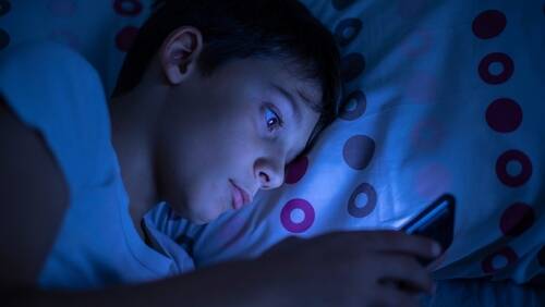 Los Angeles Social Media Addiction Lawsuit Kid on his phone at night represent an addicition to social media to a point where their parents will file a social media addiction lawsuit.