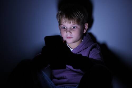 Washington Social Media Addiction Lawsuit A child on a tablet in the dark to represent an addicition to social media to the point his parents will file a social media addiction lawsuit.